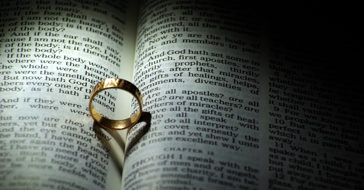 Wedding ring in a Bible with a heart shadow